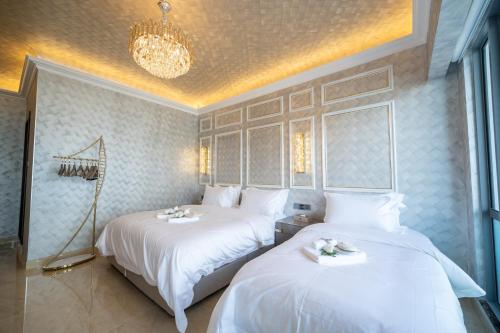 two beds in a room with white sheets at Ritz Residence, Imago Mall Loft B in Kota Kinabalu