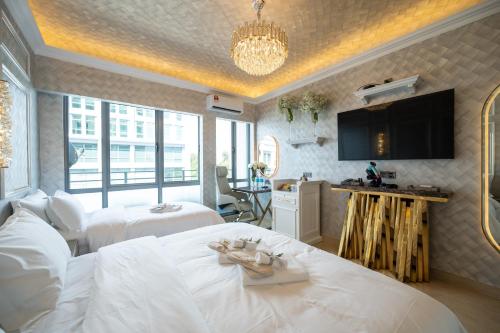 a hotel room with two beds and a television at Ritz Residence, Imago Mall Loft B in Kota Kinabalu