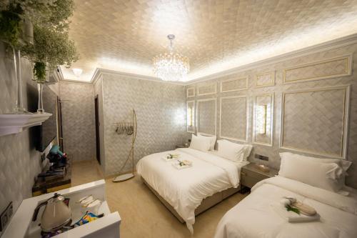a bedroom with two beds and a chandelier at Ritz Residence, Imago Mall Loft B in Kota Kinabalu