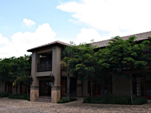a building with trees in front of it at SDG Hotel and Spa in Honeydew
