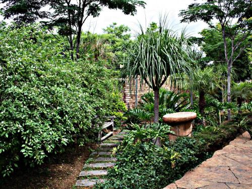 a garden with a stone path and a bench at SDG Hotel and Spa in Honeydew