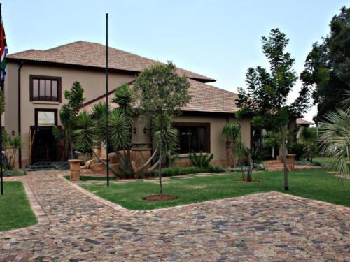a house with a brick driveway in front of it at SDG Hotel and Spa in Honeydew