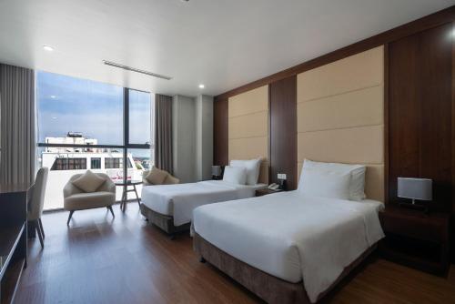 a hotel room with two beds and a balcony at Luxury6 Hotel in Móng Cái