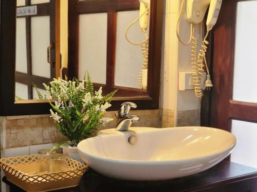 a white sink in a bathroom with a mirror at Villa Le Tam Tam Boutique Hotel in Luang Prabang