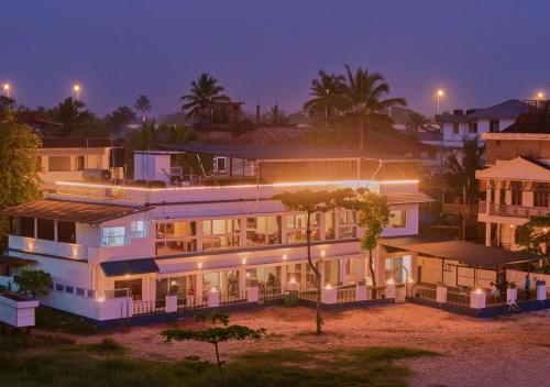 a large building with lights on at night at Alleppey Holiday Beach Resort By VOYE HOMES in Alleppey