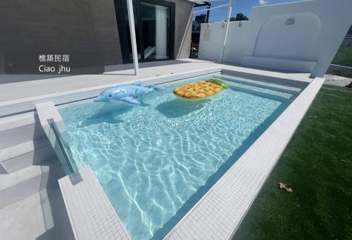a pool with a bowl of food and a toy shark at 樵築包棟泳池民宿 唱歌電動麻將烤肉 2025年6月全新裝潢 in Yuanshan