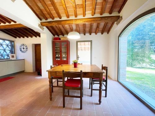 a dining room with a wooden table and a large window at Casa Nobile vicino Centro Siena in Siena