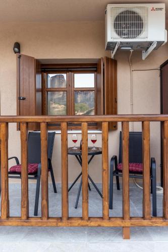 a balcony with a table with two glasses of wine at Meteora Living Rooms in Kastrákion