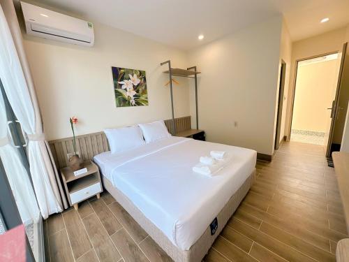 a bedroom with a large white bed in a room at Cham Charm Home Mui Ne in Mui Ne