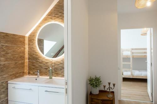 a bathroom with a sink and a mirror at Sandillon - Grande Maison Familiale Classée 3 étoiles - 5 chambres - 8 lits - à 15mn d Orléans et 20 mn de la Ferté St Aubin et de Châteauneuf sur Loire in Sandillon