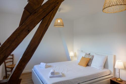 a bedroom with a white bed in a attic at Sandillon - Grande Maison Familiale Classée 3 étoiles - 5 chambres - 8 lits - à 15mn d Orléans et 20 mn de la Ferté St Aubin et de Châteauneuf sur Loire in Sandillon