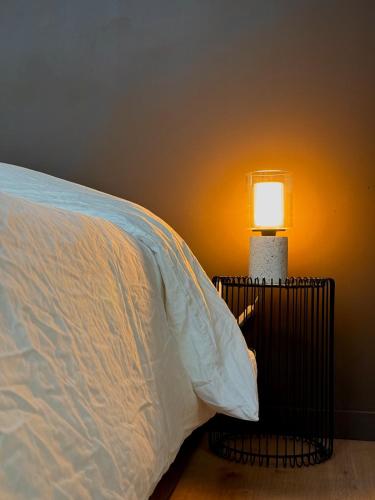 a bed with a white pillow and a lamp at Appart Spa hypercentre in Lille