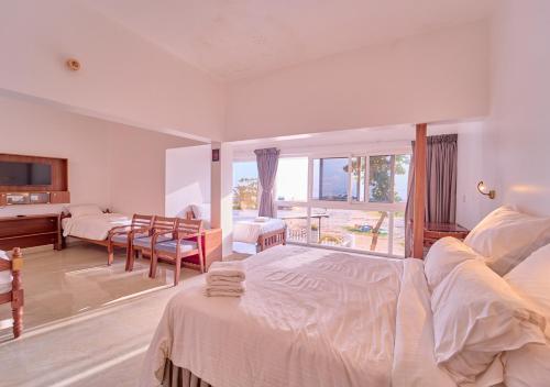 a bedroom with a bed and a living room at Alleppey Holiday Beach Resort By VOYE HOMES in Alleppey