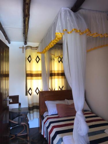 a bedroom with a canopy bed and a table at SouthCoast Outdoors in Ukunda