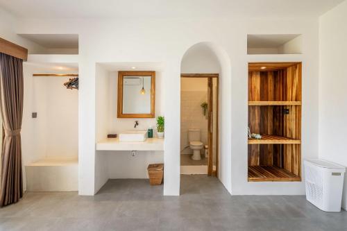 ein Badezimmer mit Waschbecken, Toilette und Spiegel in der Unterkunft Peaceful 1BR Villa near Savaya & Uluwatu - V1 in Uluwatu