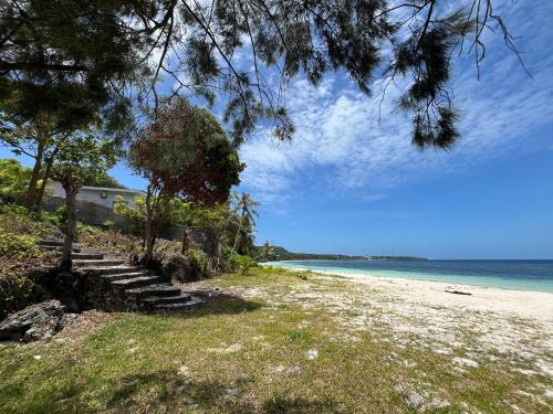 a sandy beach with stairs leading to the ocean at Bara Cabana Hotel in Bira