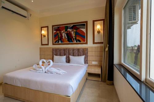 a bedroom with a bed with two towels on it at Elysiumarc Hotel & Resort 