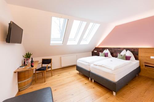 a bedroom with a bed and a desk and a tv at IBY-LEHRNER WEIN-GUT und WEIN-Träumerei in Horitschon