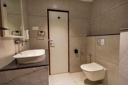 a bathroom with a toilet and a sink at Elysiumarc Hotel & Resort 