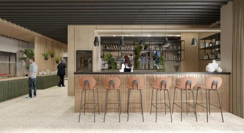 a lobby with a bar with stools in front of it at Hotel Florian&Godler in Karlovac