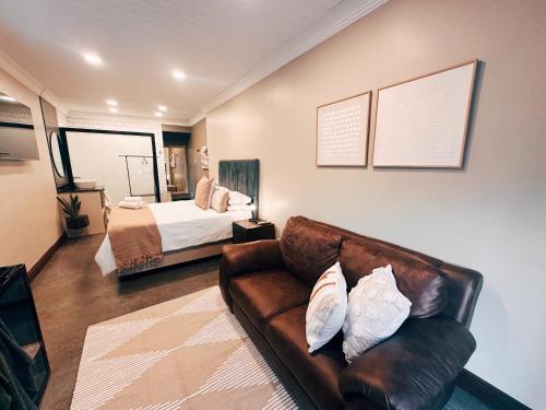 a living room with a couch and a bed at Boutique On Madeliefie in Welkom