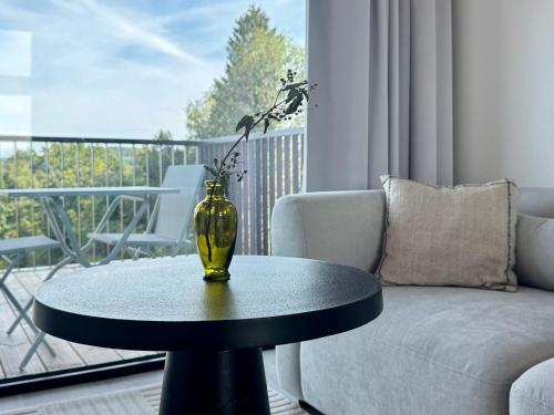 a vase on a table in a living room with a couch at KODAS Loft - confort et nature in Hommert