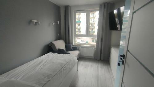 a small bedroom with a bed and a window at 3-Bedroom Apartment with 2 Free Parking Spots - TAURON ARENA in Kraków