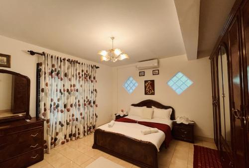 a bedroom with a bed and a chandelier at Villa Monza in Kandy