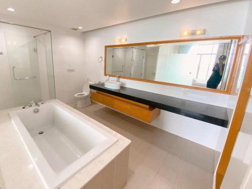 a bathroom with a large white tub and a mirror at Biệt thự sealinks và căn hộ studio Ocean vista Sealinks Mũi Né in Phan Thiet