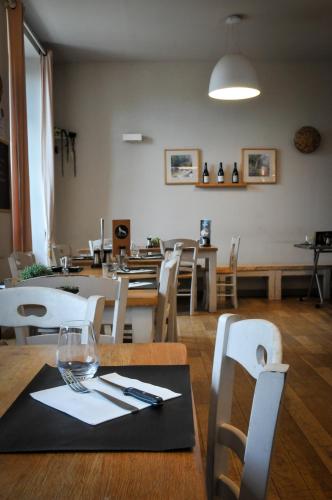 a dining room with a table and white chairs at Auberge de la fontaine aux loups in Saint-Sulpice-le-Dunois