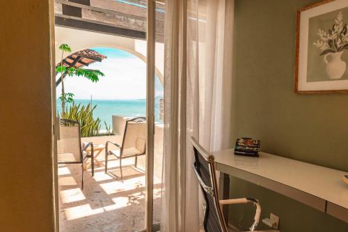a room with a desk and a view of the ocean at Luxury Oceanview Condo with heated Pool in Puerto Vallarta