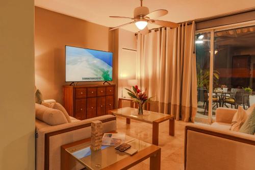 a living room with a couch and a flat screen tv at Luxury Oceanview Condo with heated Pool in Puerto Vallarta