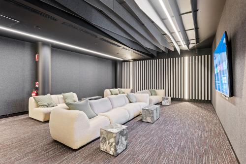 a living room with white couches and a flat screen tv at Self-Contained Apartment in Woden By Serain in Phillip
