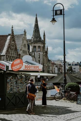 a couple of people standing in front of a market at Raibu Ghent by StayC in Ghent