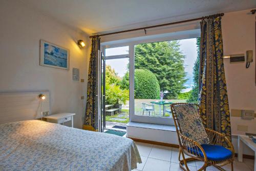 ein Schlafzimmer mit einem Bett und einem großen Fenster in der Unterkunft Villa Panorama in Porto Valtravaglia