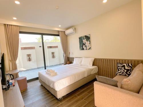a bedroom with a large bed and a couch at Cham Charm Home Mui Ne in Mui Ne