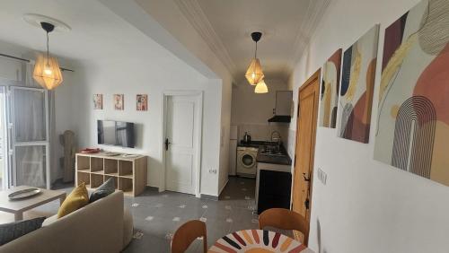 a living room with a couch and a kitchen at Chic & Cozy Apartment by the Sea - MARTIL in Martil
