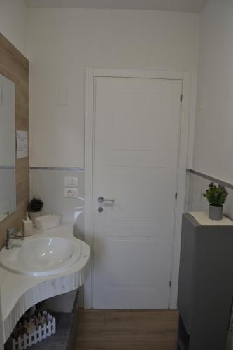 a bathroom with a sink and a white door at Guest Room Nesea in Pellaro