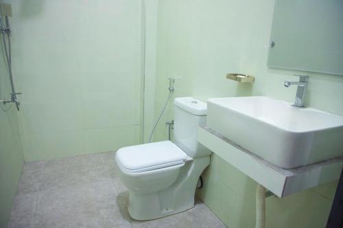 a bathroom with a white toilet and a sink at Kingsland Tourist Home in Polonnaruwa