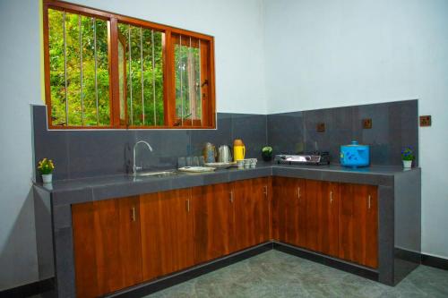 a kitchen with a sink and a window at Kingsland Tourist Home in Polonnaruwa