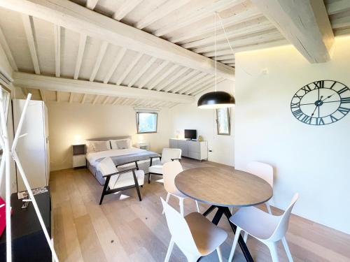 una stanza con tavolo, letto e orologio di Casa Brunello vicino centro Siena a Siena