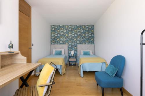 a room with two beds and a table and chairs at Vitoria-Gasteiz magnífica casa in Vitoria-Gasteiz