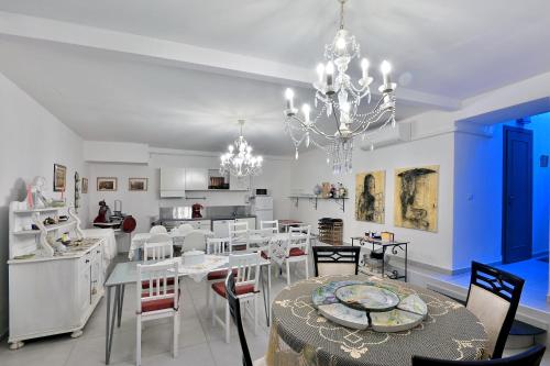 a dining room with white tables and chairs and a chandelier at Ca' Rossa in Roe