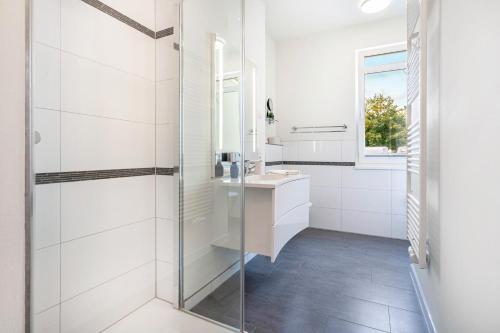 a bathroom with a glass shower and a sink at Wohnung Wilma - Villa Wiederkehr in Ostseebad Sellin