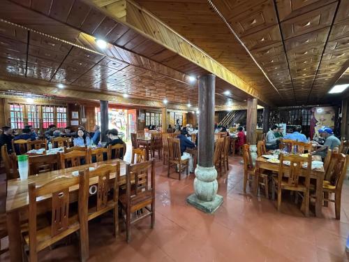 a dining room with people sitting at tables at Samu Bac Ha Hotel in Lao Cai
