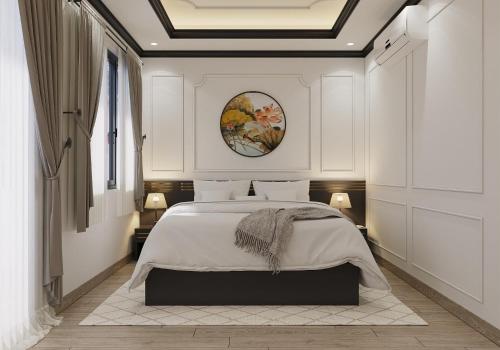 a bedroom with a large bed with white walls at Milestone Premium Boutique Hotel in Ho Chi Minh City