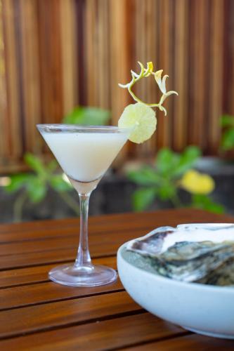 a martini glass with a green leaf on a table at Serendipity Mirissa in Mirissa
