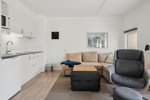 a living room with a couch and two chairs at Karrebaeksminde Strandhotel in Karrebæksminde