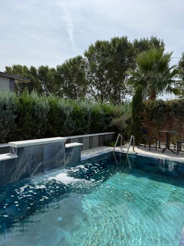 a swimming pool with a slide in the water at Villa REJA Hamallaj in Draçi