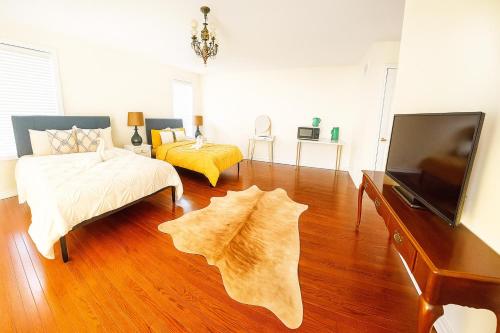 a living room with a bed and a flat screen tv at luxurious Private Master bedroom in Markham